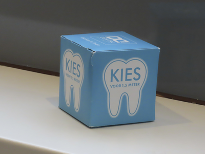 901854 Afbeelding van een kartonnen kubus met de tekst 'KIES VOOR 1,5 METER' tijdens de coronapandemie, in de ...